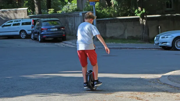 Rider de dos sur une monoroue électrique dans une rue urbaine