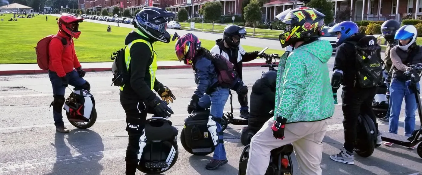 Groupe de riders casqués avec des gyroroues dans une rue