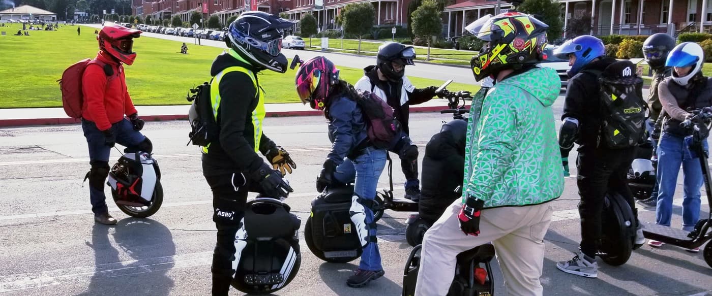 Groupe de riders de gyroroue en casque intégral avec genouillères et gants de protection